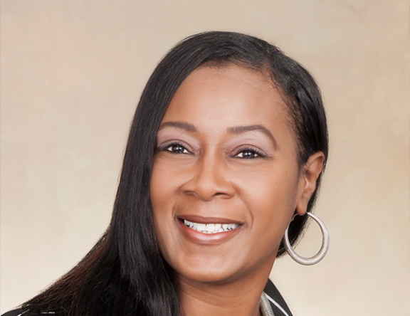 A picture of Jeanette, a woman with brown hair and eyes smiling at the camera