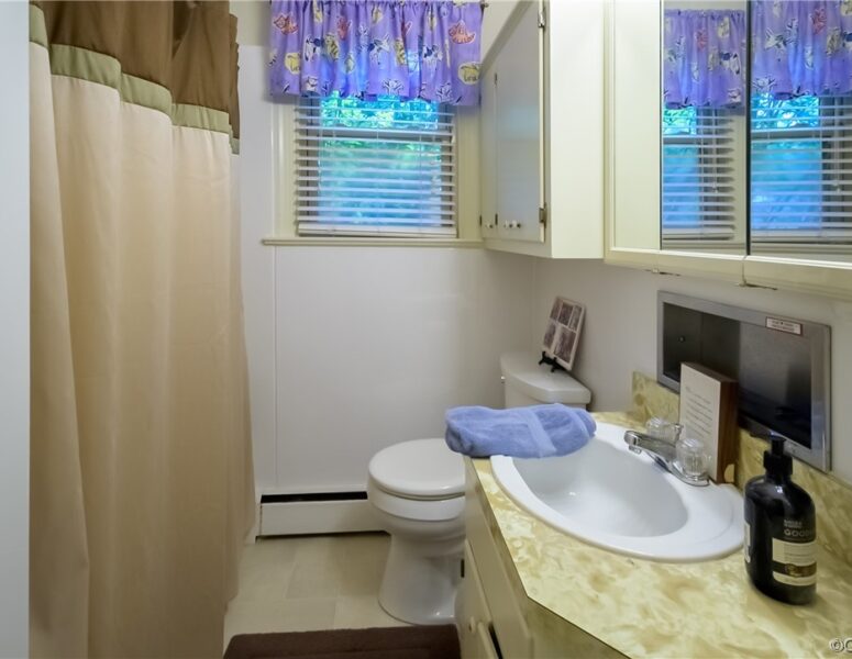 A bathroom with a toilet, sink, and shower tub combination