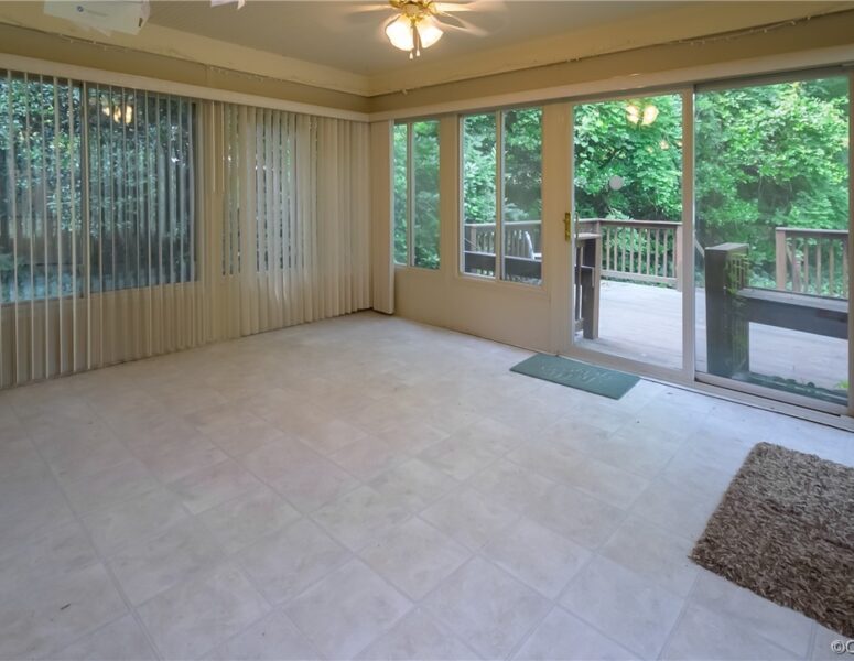 A picture of a sunroom leading to a porch