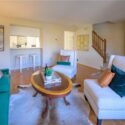 living room with kitchen bar and stairs leading to second floor