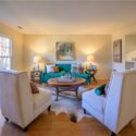 living room with green couch and white chairs
