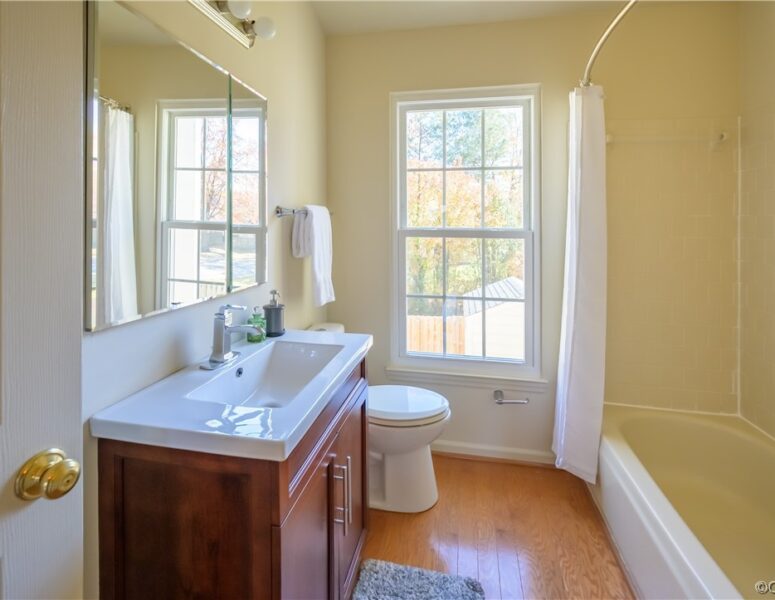 A bathroom with yellow walls and a modern sink